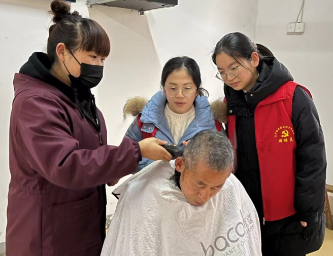 合肥市庐江县泥河镇居民刘正芳向青年志愿者传授理发技术，弘扬志愿者精神