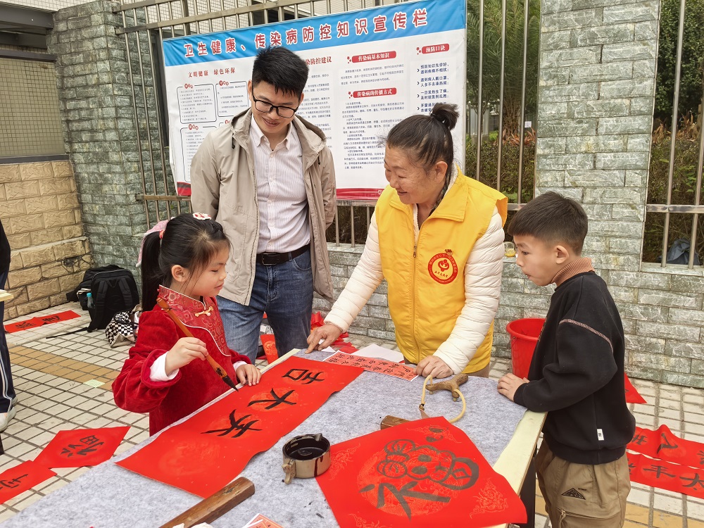 “五老”志愿者一边给小朋友讲春联的来历和寓意 一边指导小朋友写对联1.jpg