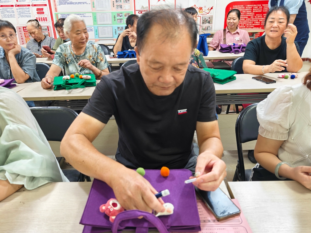 【“毡间藏韵 手作生花”】居民认真装饰毛毡包.jpg