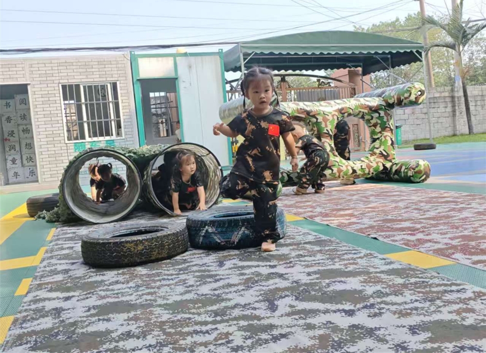 2025年10月11日，广西柳州市鱼峰区蟠龙社区关工小组开展“童心筑国防，共绘迷彩梦”国防教育进校园活动——小朋友们过障碍物环节.jpg