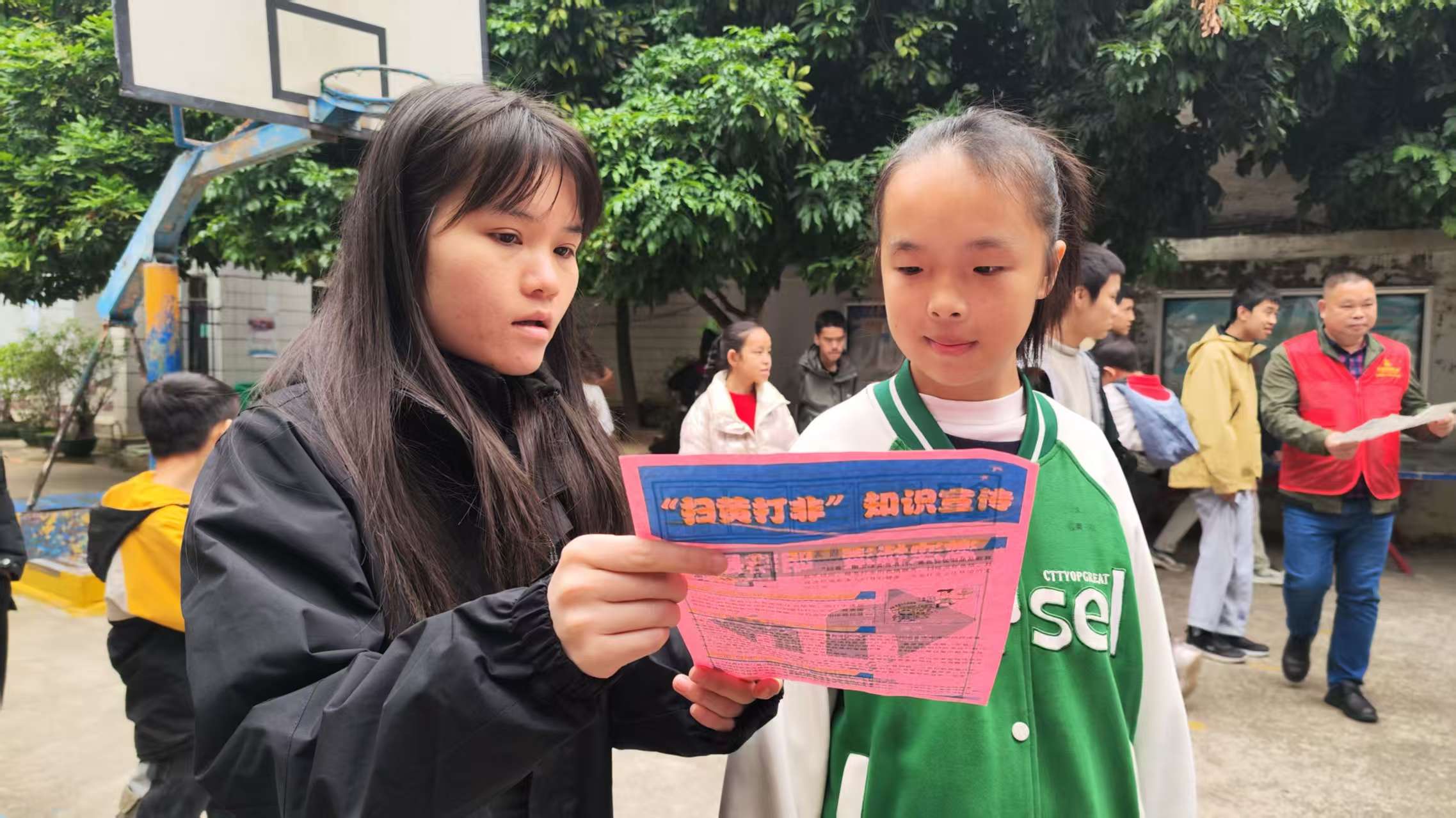 1767515962945667.jpg 志愿者向学生发放“扫黄打非”宣传单.jpg