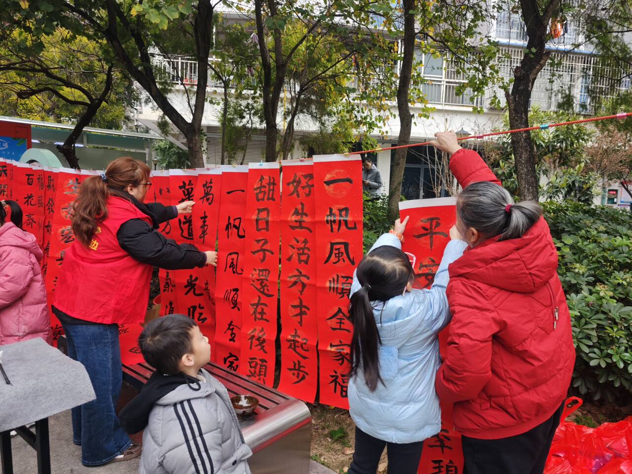 1770193124469430.jpg 老少携手挂春联.jpg